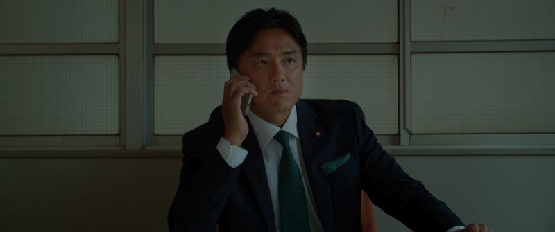 電話を受ける塚本明